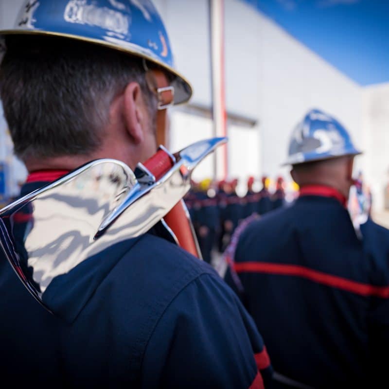 Sapeurs-pompiers en tenue de cérémonie lors d'une prise d'armes